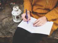 a photo of a person drawing in a journal
