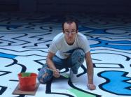 Haring painting the backdrop for the Palladium nightclub, 1985