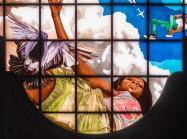 Kehinde Wiley stained glass woman showing a young black woman looking down at the viewer