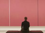 man sitting in front of pink canvas