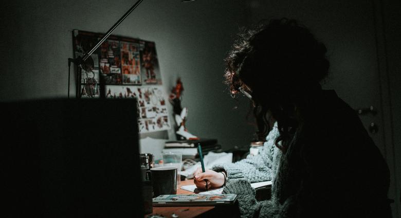 a person sits at a desk with a lamp