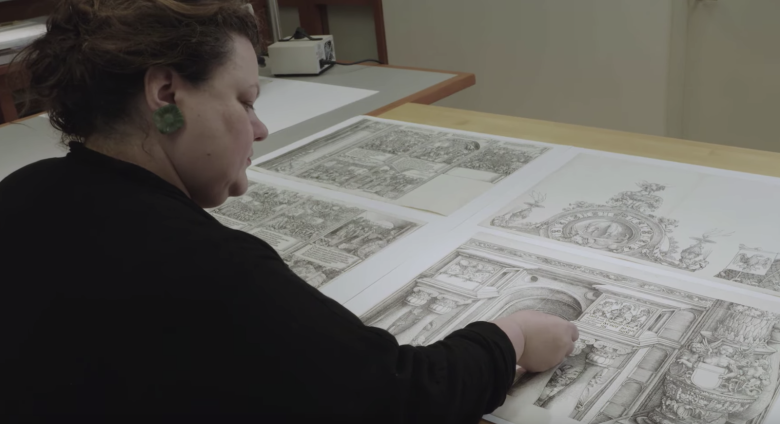 conservator studies several prints