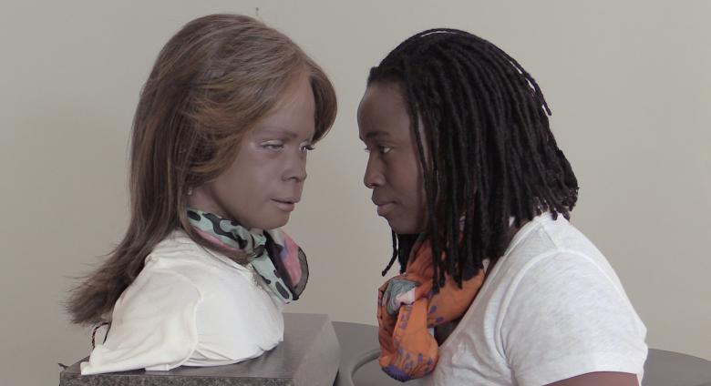 photo of a woman and a silicone clone of herself looking each other in the eye