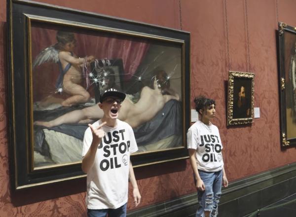 Just Stop Oil activists standing by the Rokeby Venus after hitting the protective glass with safety hammers.