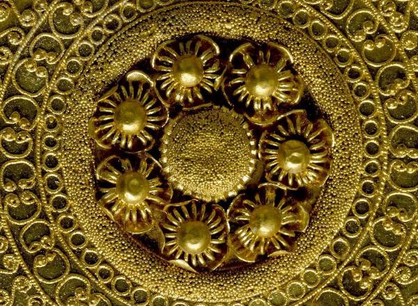 Detail shot of a gold ear-stud: disc decorated with granulation, filigree and beaded wire. 530BC-500BC