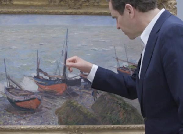 two museum workers study monet up close