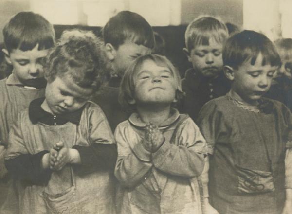 group of small children close their eyes in prayer