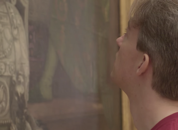 man stares at detail of The Wedding Feast at Cana