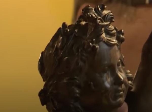 Brand stands for a photo with the bronze statue