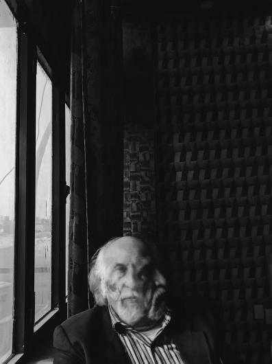 black and white photograph of a man on a train, his face caught in motion