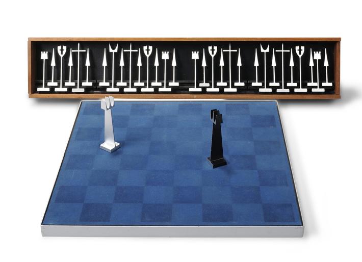 aluminum chess pieces on a blue chessboard